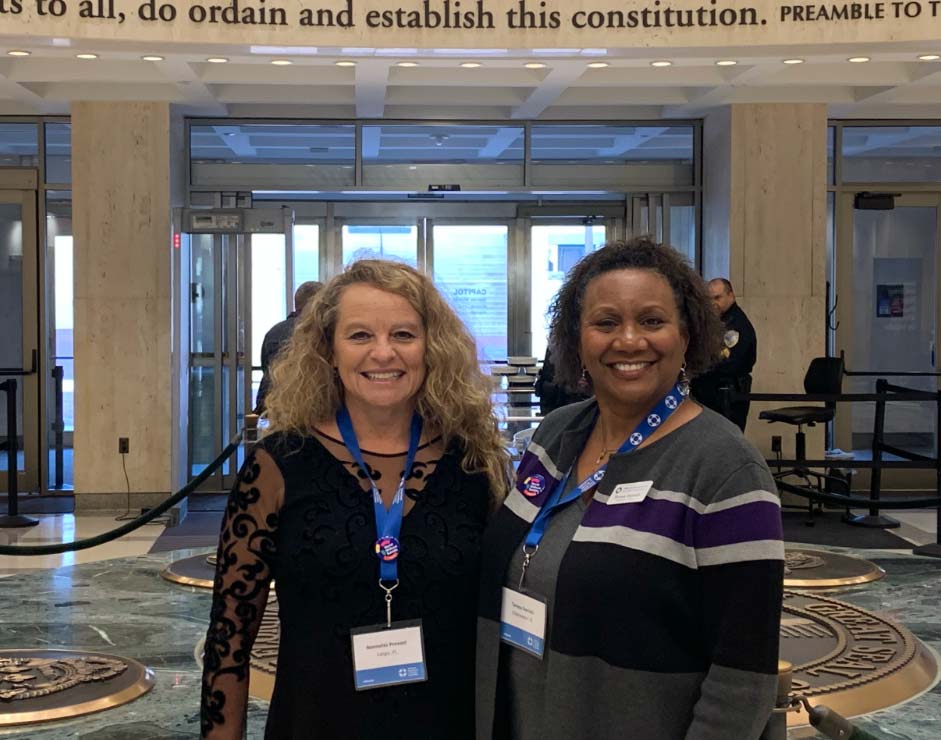 Two women with passes, posing indoors