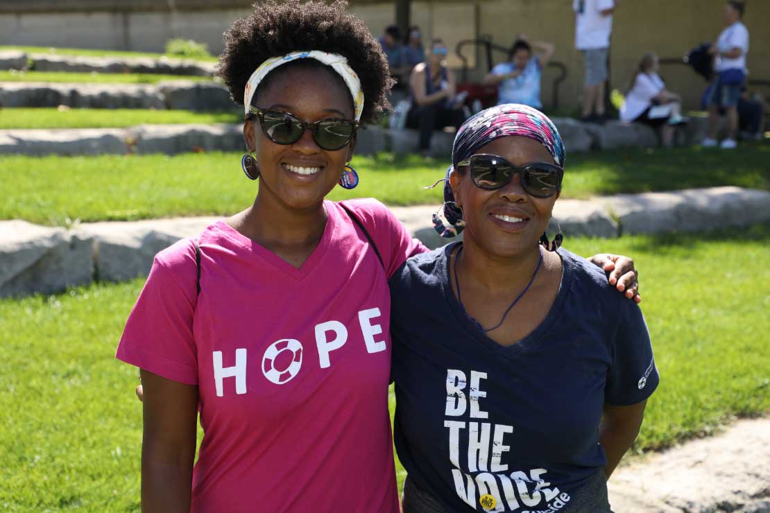Women posing in Hope and Be the Voice t-shirts